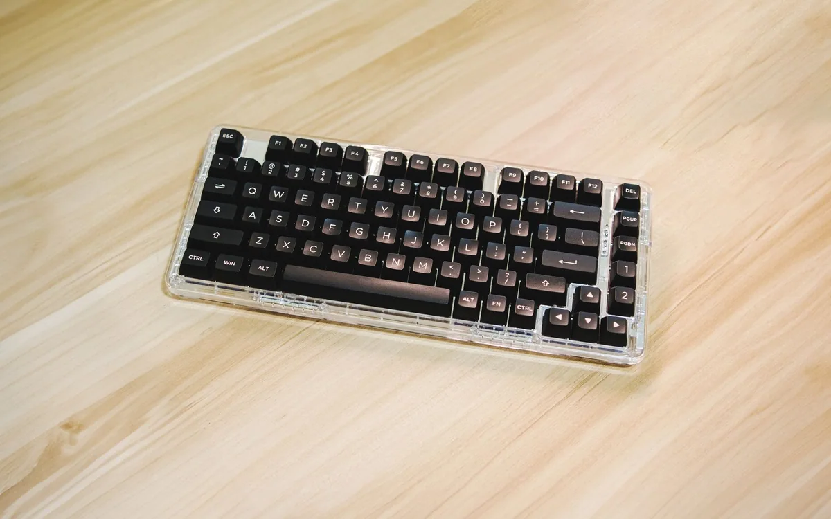 A compact mechanical keyboard on a wooden desk.